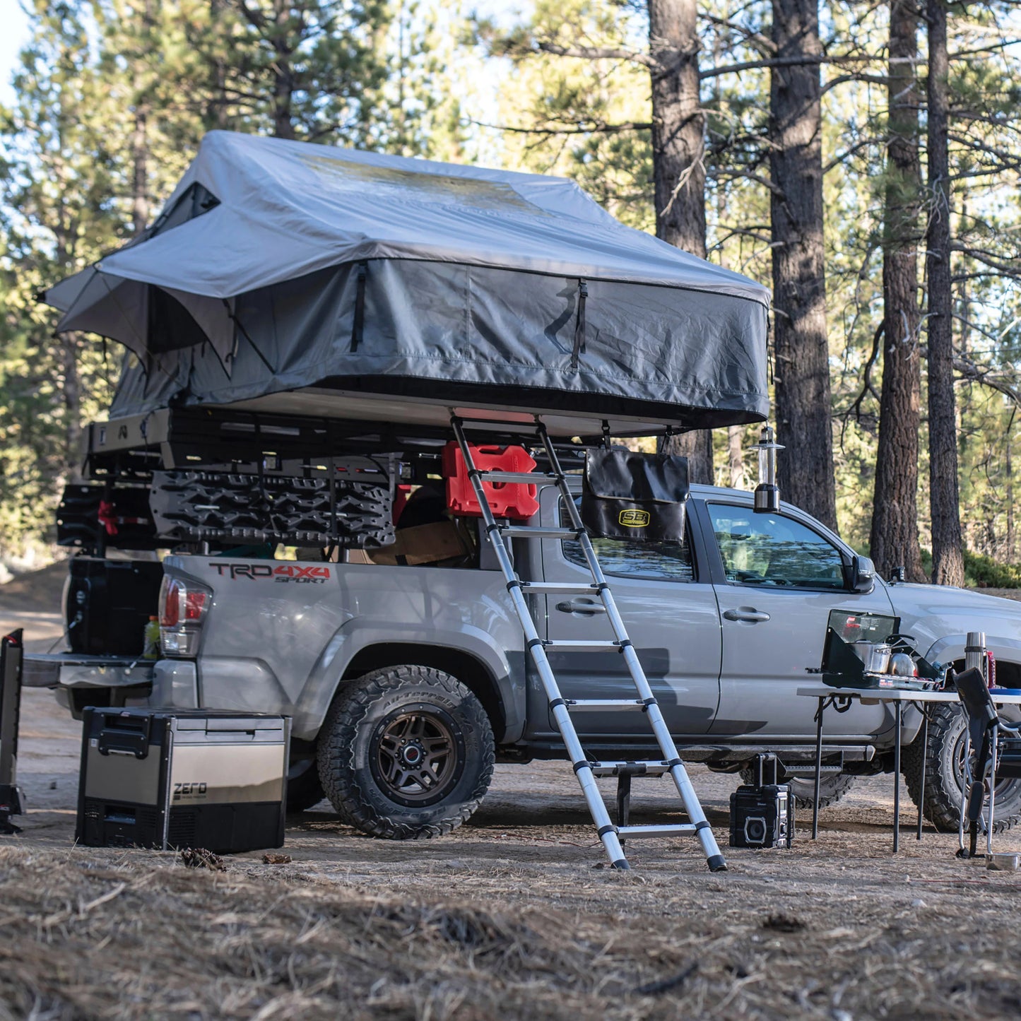 Overlanding vehicle with Smittybilt Gen2 Overlander Tent deployed at campsite, demonstrating spacious rooftop tent for 3-4 campers
