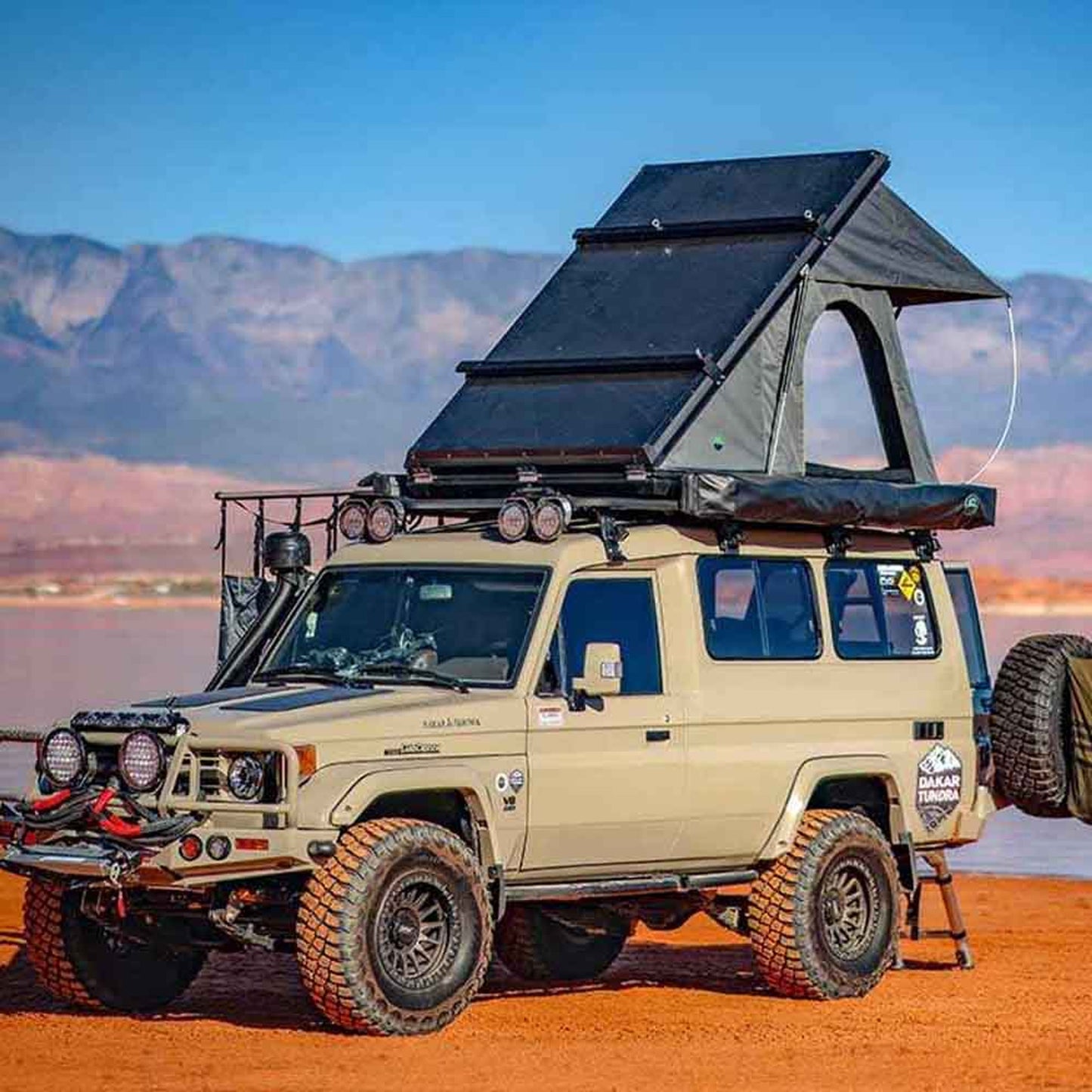 OVS Mamba Clamshell tent mounted on 4x4 vehicle in desert terrain
