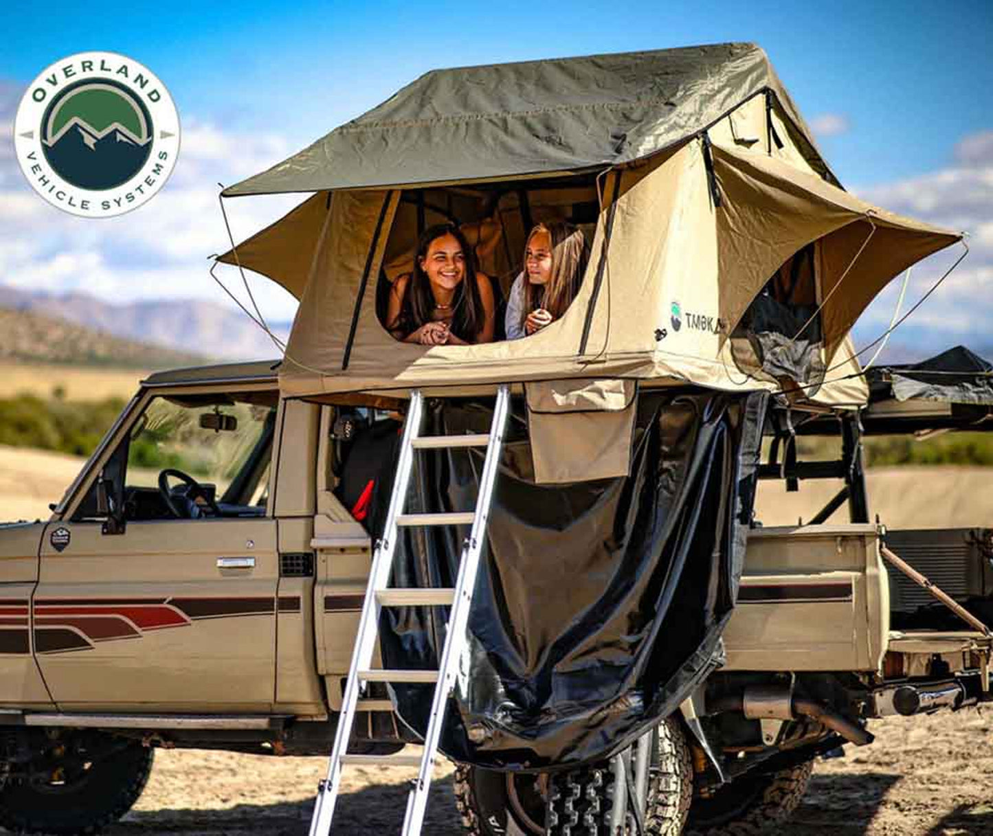 OVS TMBK 3 rooftop tent mounted on truck with ladder extended at campsite