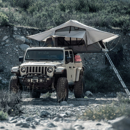 Jeep with Smittybilt Gen2 Overlander Tent deployed at rocky off-road campsite
