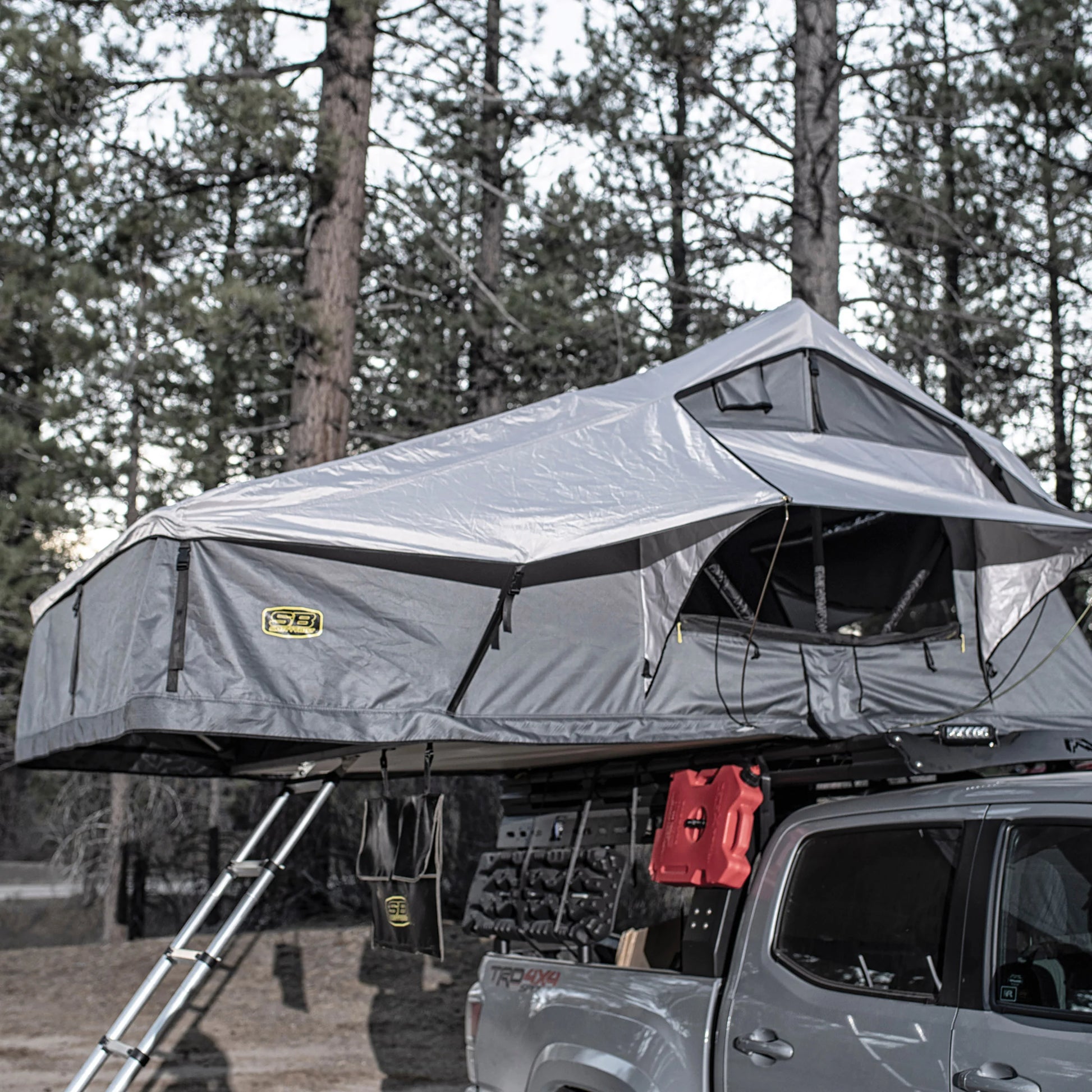 Truck with Smittybilt Gen2 Overlander Tent deployed at campsite, demonstrating spacious rooftop tent for 3-4 campers