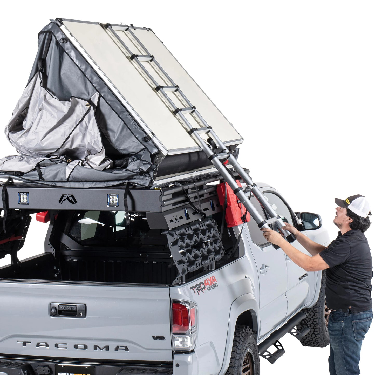 Smittybilt Gen2 Overlander Tent being unfolded on pickup truck, demonstrating fast rooftop tent setup process