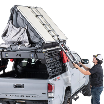 Smittybilt Gen2 Overlander Tent being unfolded on pickup truck, demonstrating fast rooftop tent setup process