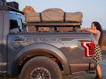 Ford pickup with FrontRunner Slimline 2 Full Truck Bed Rack Kit parked in scenic open landscape, rooftop tent and rack ready for adventure