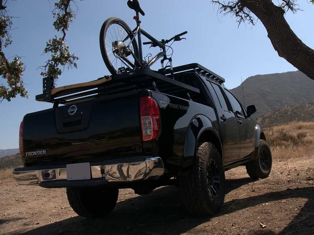 Nissan pickup truck overlanding with FrontRunner Slimline 2 Full Truck Bed Rack Kit and mounted bike, showing versatile cargo carrying capability