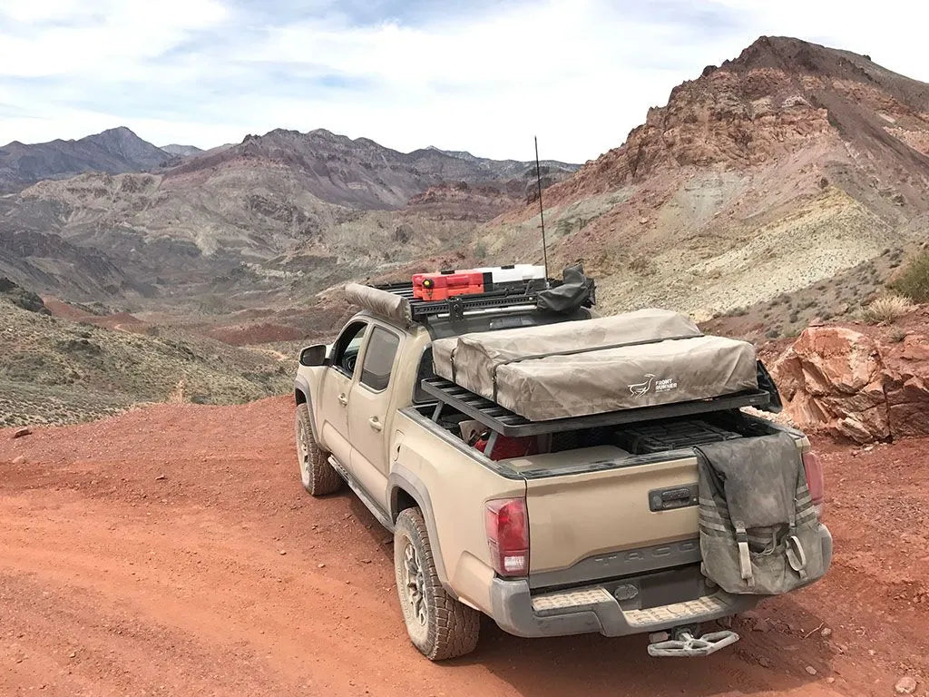 Toyota pickup overlanding on desert trail with FrontRunner Slimline 2 Full Truck Bed Rack Kit, loaded with rooftop tent and adventure gear